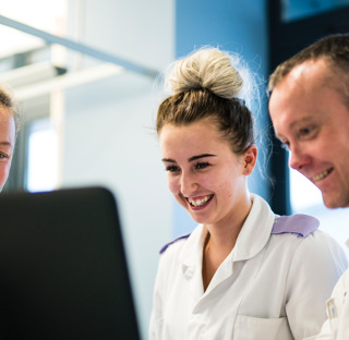 student cadet nurse with nurses in hospital smiling