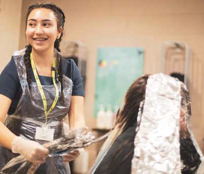 student hairdresser applying hair foils to client