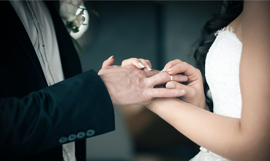 close up of bride and groom exchanging rings