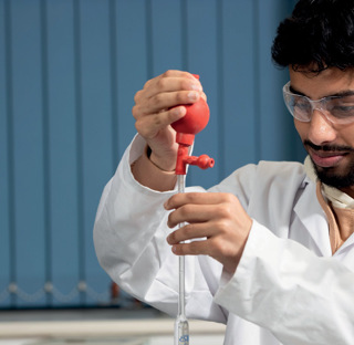 male student holding test tube science equipment