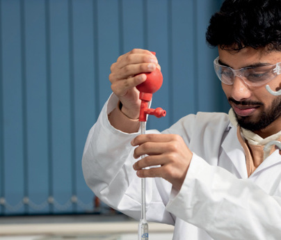 male student holding test tube science equipment