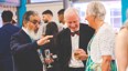 Principal Fazal Dad talks to guests at formal dinner party