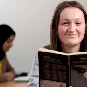 student reading book - Othello smiling to camera