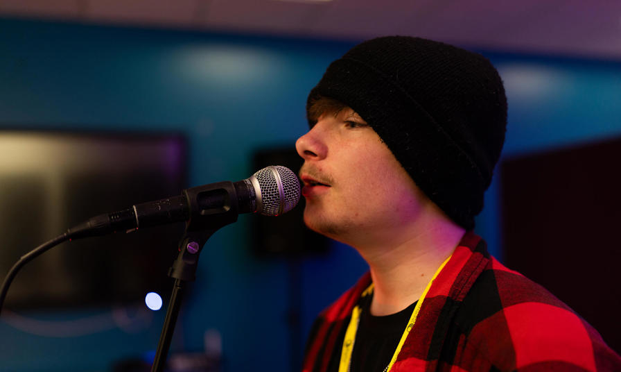 male student singing on a microphone 