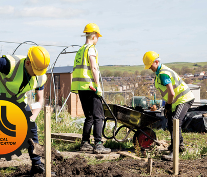 construction students digging soil and filling wheelbarrow