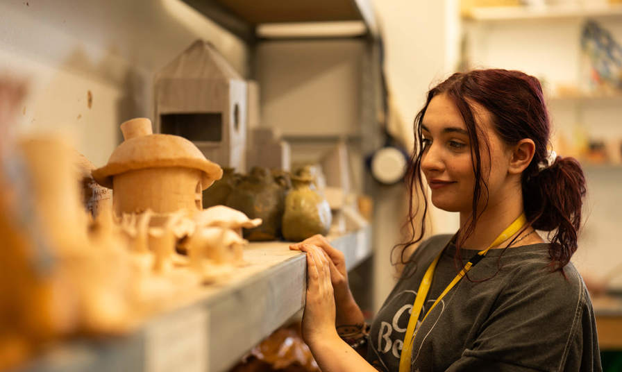 Young girl looking at sculptures on a shelf