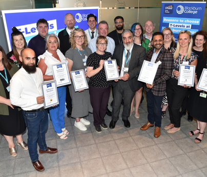 group of people holding certificates in front of T Level banners