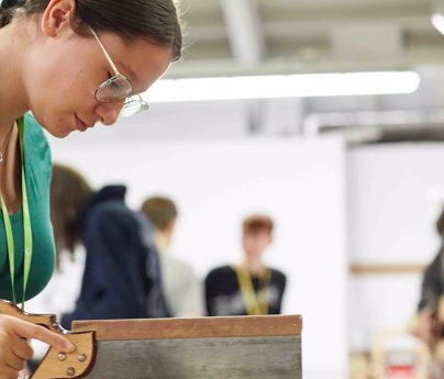 Female working on joinery equipment