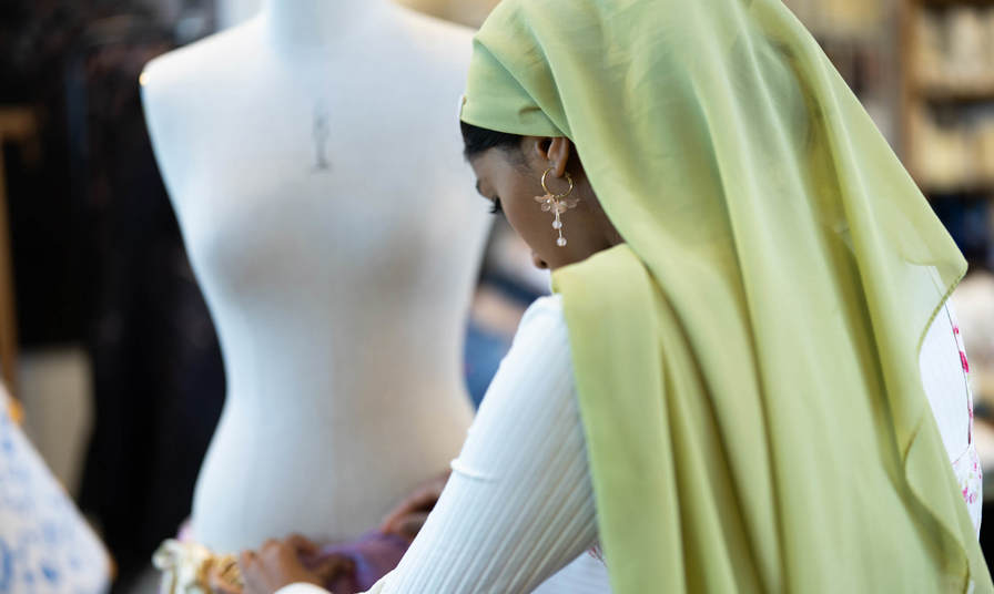 Girl using a sewing mannequin