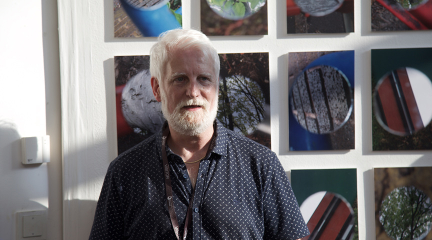 man stands in front of artwork windows