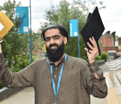 Baba Khan holds golden envelope and graduation cap