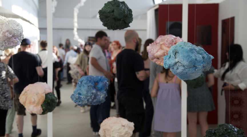 Hanging art of expanding foam painted in art exhibition with crowds of people