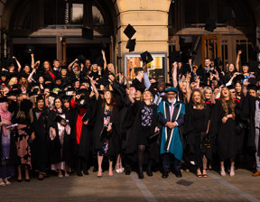 Large group of graduates throwing hats into the air