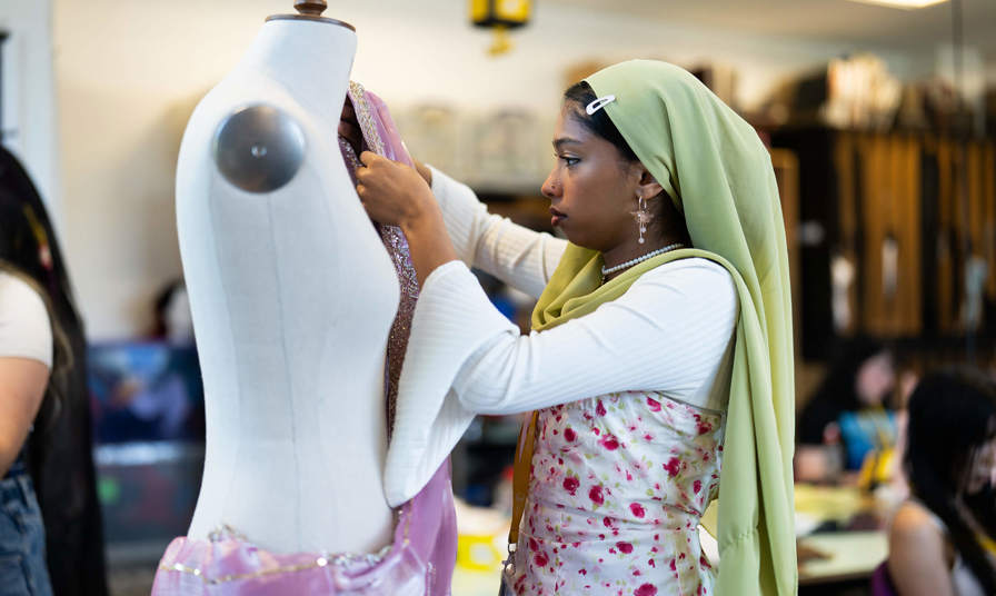 Image of a girl using a sewing mannequin