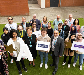 group of students and tutors holding signs including Lancaster University, University of Oxford, Manchester University and University of Central Lancashire