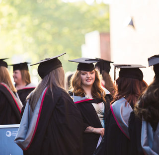 group of graduates waiting around camera focuses in on one woman