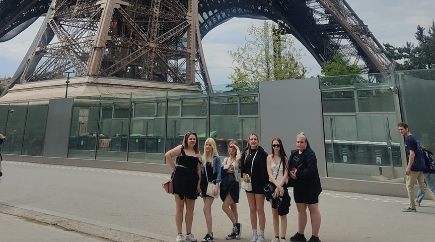 group of students stood outside base of the Eiffel Tower