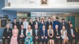 group of people in formal dinner wear in rows pose for photo