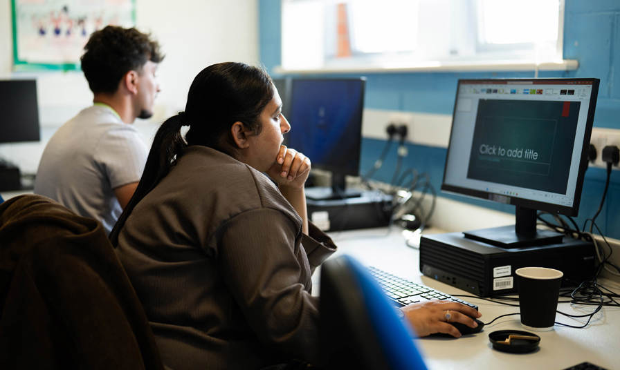 Student creating a PowerPoint presentation on a PC 