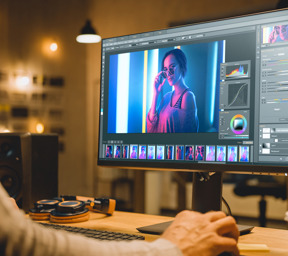 person working at computer with colourful photos on the screen