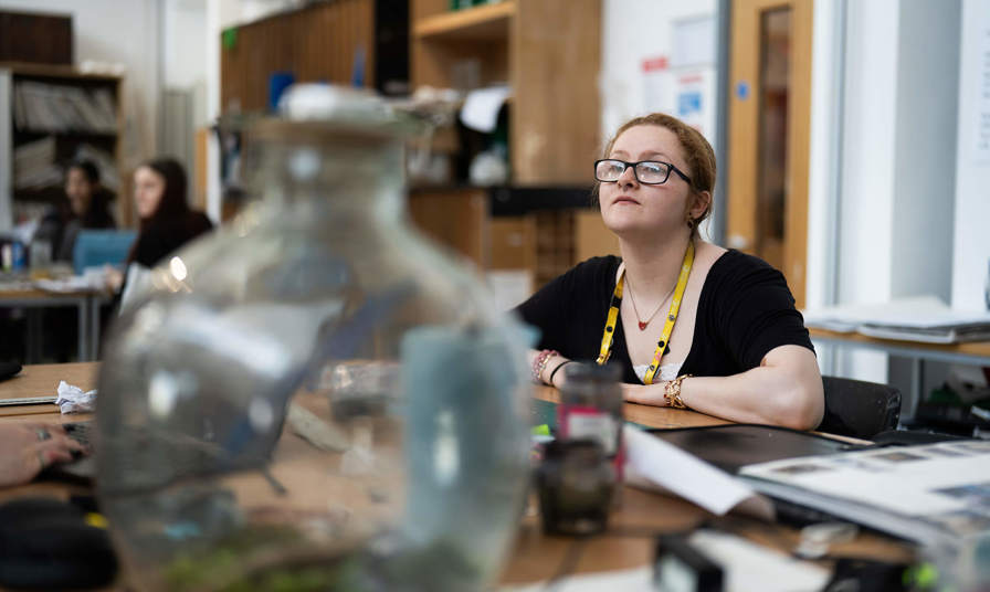 Girl sat at a table in an art class