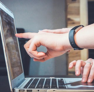 hands pointing at screen of open laptop