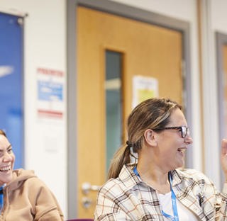 students smiling and laughing during classroom discussion