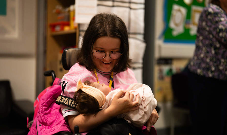 Young girl holding a practice baby doll