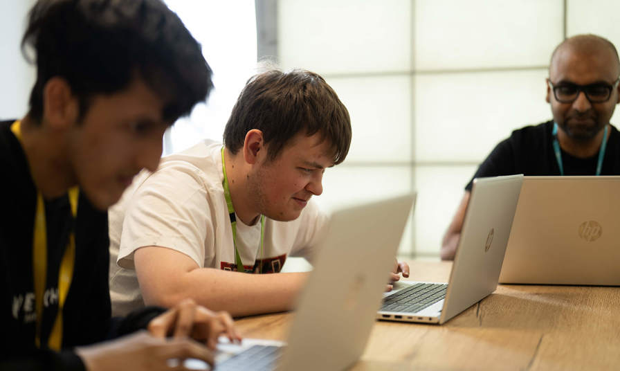 Students and tutor using laptops 