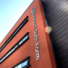 Blackburn Sixth Form sign on side of orange brick building