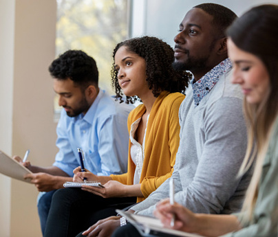 group of people sit together making notes