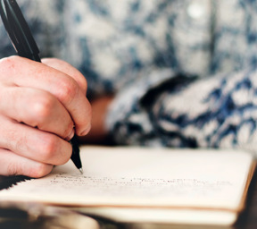 close up of person writing in notebook