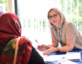 woman offering advice and talking to woman at table