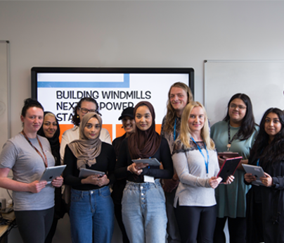 group of students holding ipads smiling to camera