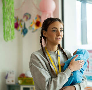 Student holding artificial baby 