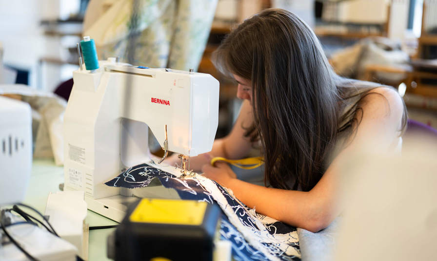 Girl sat at a sewing machine