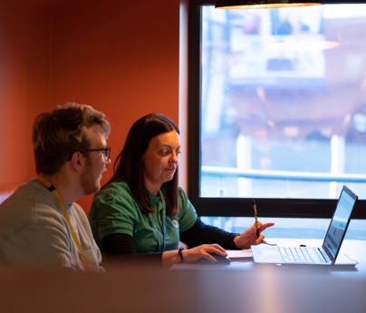 student sat with careers advisor in a booth looking at a laptop