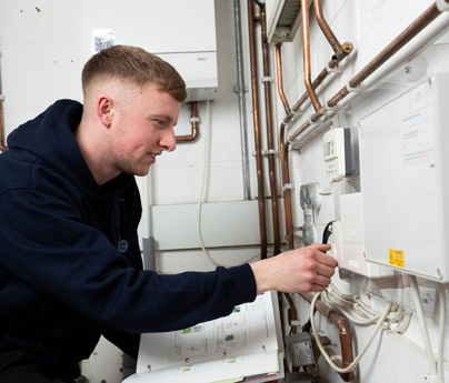 plumbing student working on boiler with manual