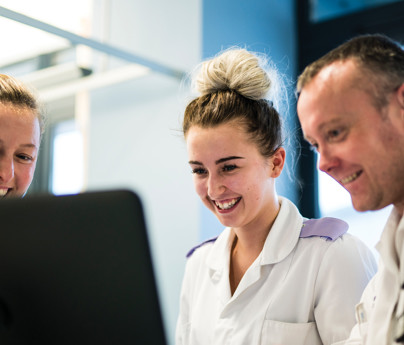 student cadet nurse with nurses in hospital smiling