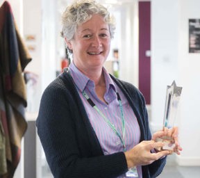 Portrait of woman Joanne Harris smiling holding trophy