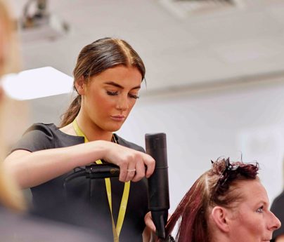 hairdressing student blow dries hair of a women