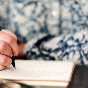 close up of person writing in notebook