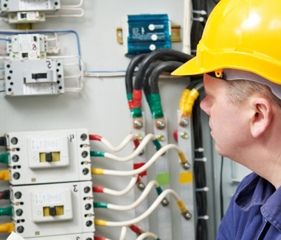 man in hard hat looking at electrical cabling