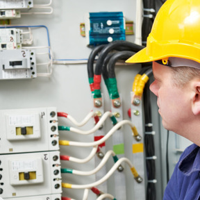 man in hard hat looking at electrical cabling