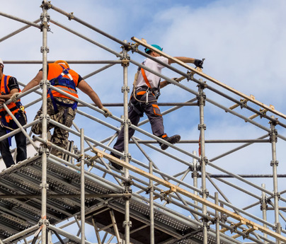 workmen in harnesses and high-vis jackets on scaffolding