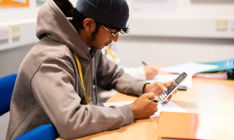 young male student using a calculator