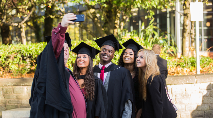 group of graduates pose for selfie