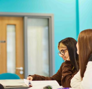 Group of students actively learning around a desk