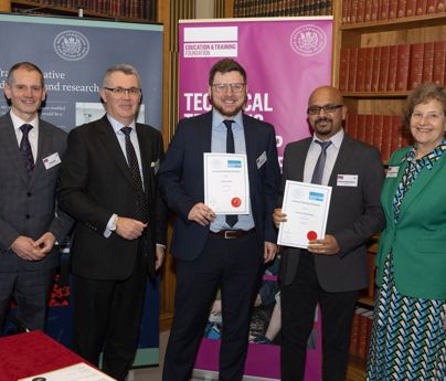 group of 4 men and 1 woman stood up, 2 men are holding certificates saying Technical Teaching Partnership