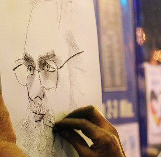 close up of person creating charcoal drawing of a face